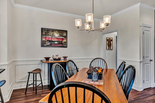 dining room with ornamental molding, a notable chandelier, a decorative wall, and wood finished floors