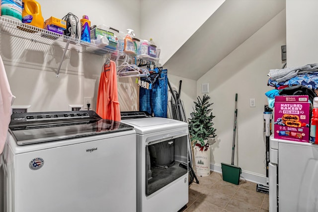 clothes washing area with laundry area, light tile patterned floors, baseboards, and independent washer and dryer