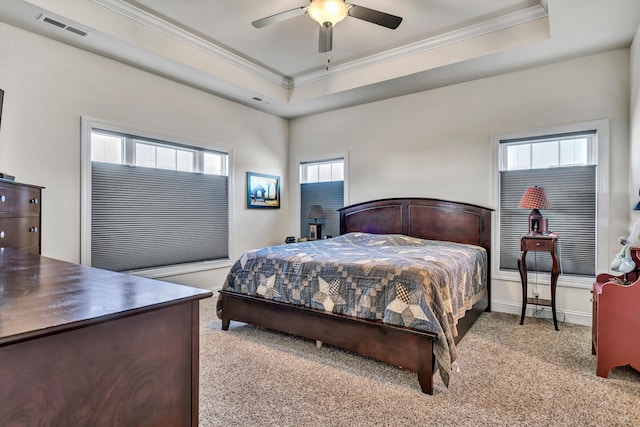 bedroom with ornamental molding, a tray ceiling, visible vents, and carpet flooring