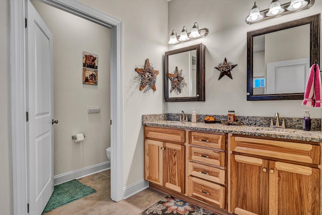 full bathroom with tile patterned flooring, a sink, toilet, and double vanity