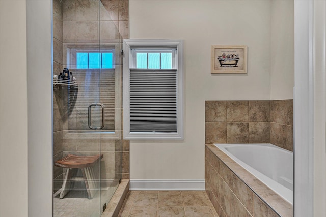 full bath with a stall shower, tile patterned flooring, baseboards, and a bath