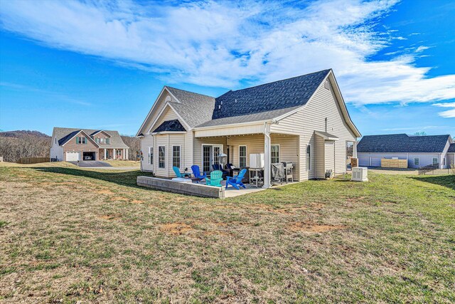 rear view of house with a patio, a yard, roof with shingles, and cooling unit