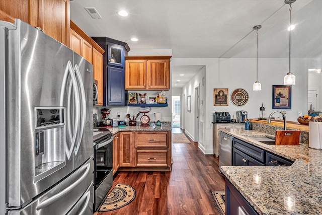 kitchen featuring dark wood-style floors, glass insert cabinets, appliances with stainless steel finishes, light stone counters, and a sink