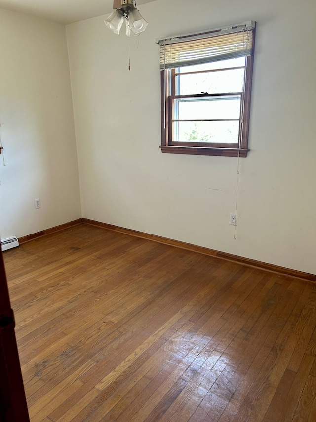 unfurnished room with a baseboard radiator, baseboards, ceiling fan, and hardwood / wood-style floors