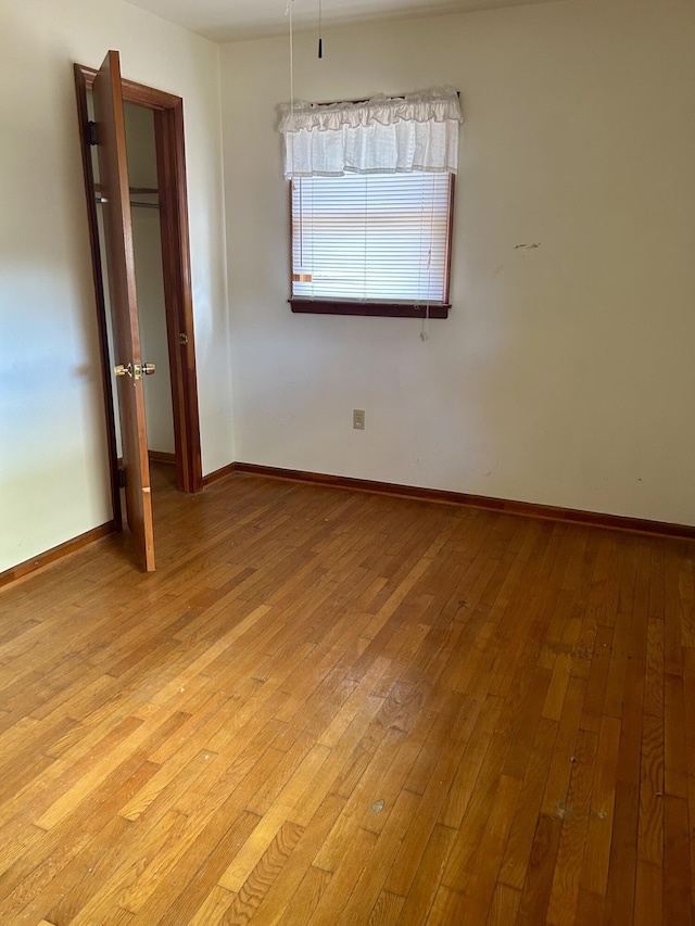 unfurnished bedroom with light wood-type flooring and baseboards