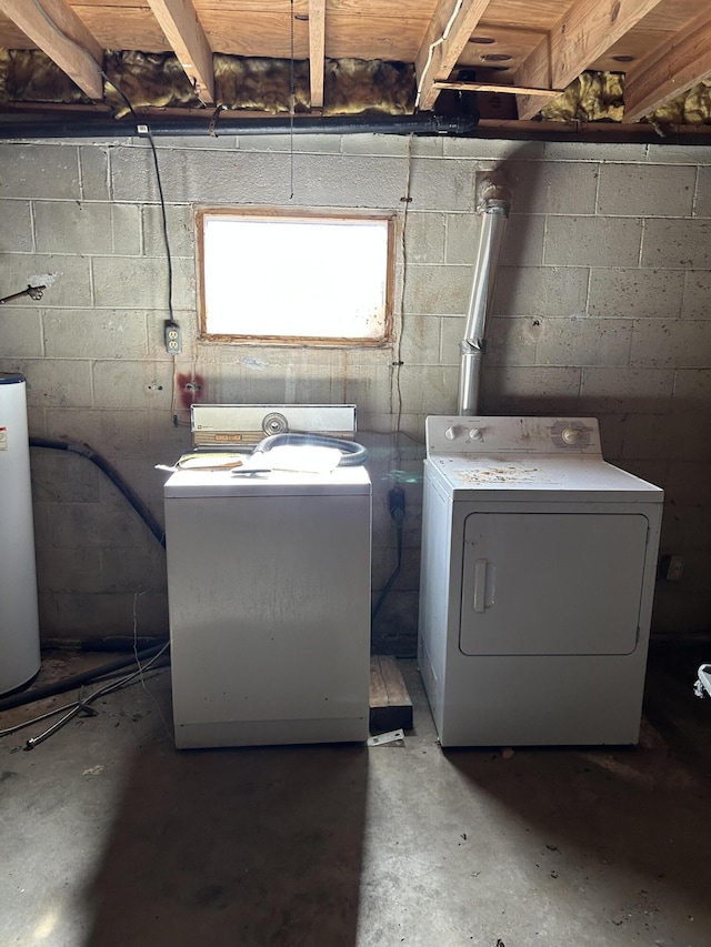 clothes washing area with laundry area, water heater, and washer and clothes dryer