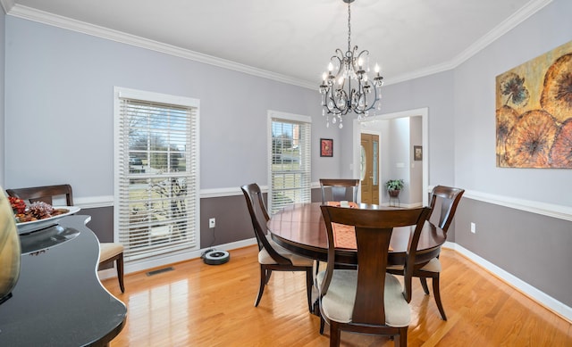 dining room featuring ornamental molding, visible vents, light wood-style flooring, and baseboards