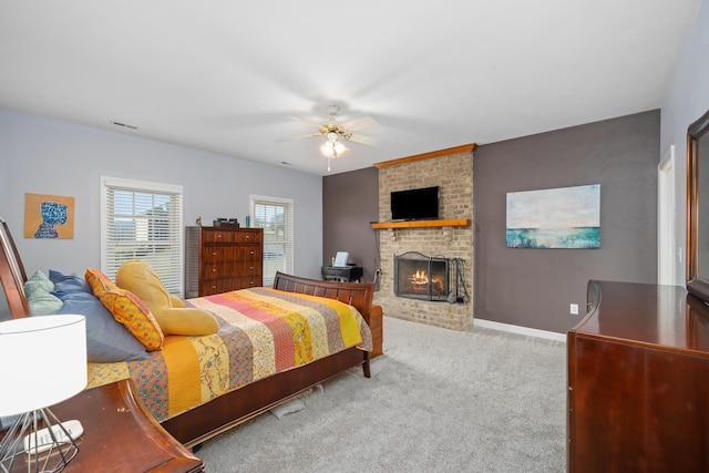 carpeted bedroom with visible vents, a fireplace, baseboards, and ceiling fan