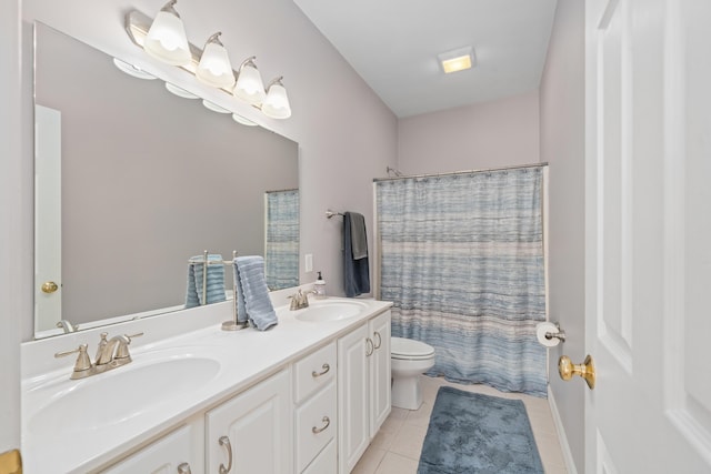 bathroom featuring toilet, tile patterned flooring, double vanity, and a sink