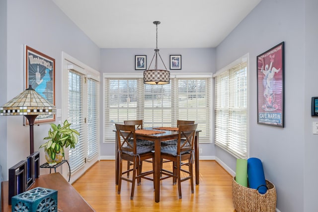 dining space featuring light wood finished floors and baseboards