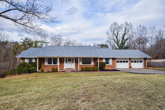 ranch-style house featuring a garage, brick siding, aphalt driveway, and a front yard