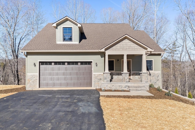 view of front of house with covered porch, aphalt driveway, roof with shingles, and an attached garage