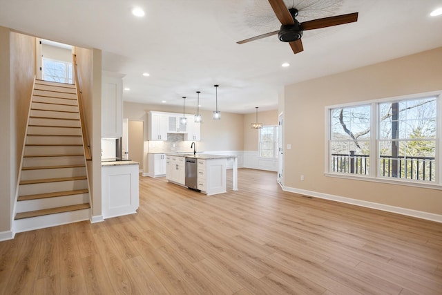 kitchen with light wood-style floors, light countertops, stainless steel dishwasher, and recessed lighting