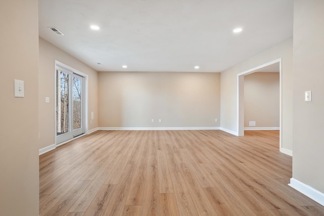 empty room with light wood-type flooring, visible vents, baseboards, and recessed lighting