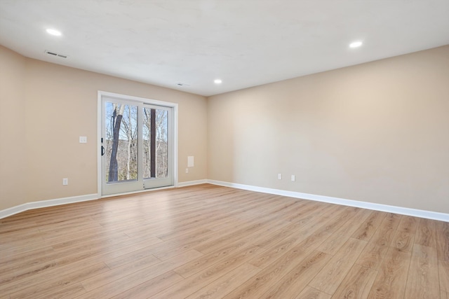 empty room featuring light wood-type flooring, baseboards, and visible vents