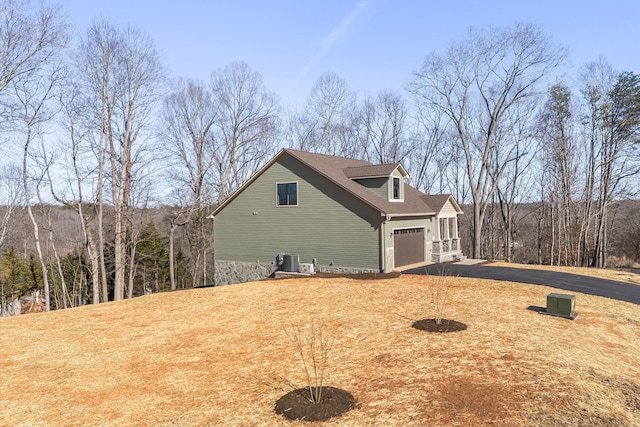 view of home's exterior with aphalt driveway and cooling unit