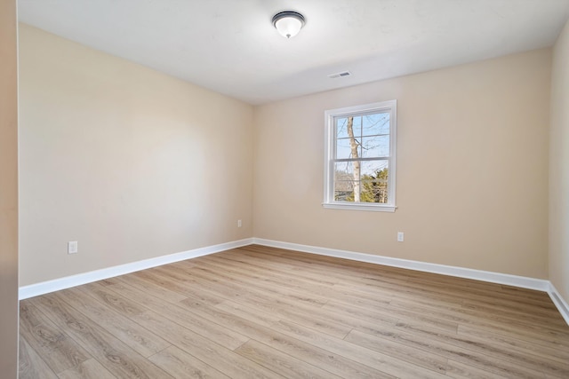 unfurnished room featuring light wood-style flooring, visible vents, and baseboards