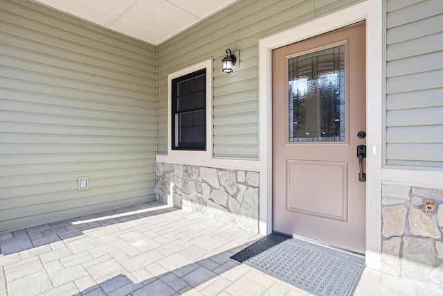 doorway to property with stone siding