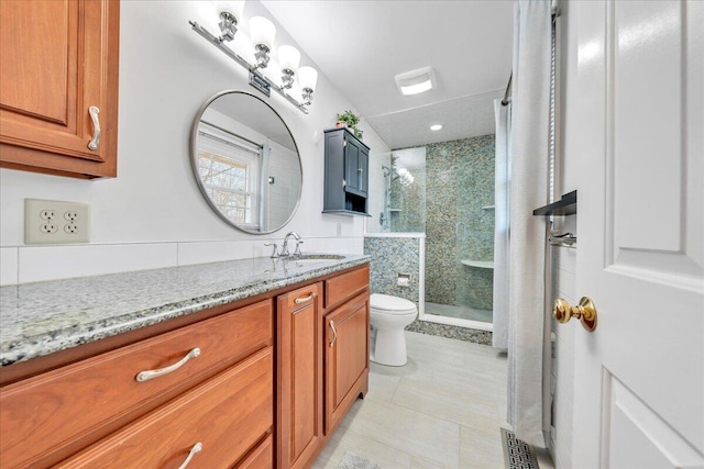 bathroom with tile patterned floors, a shower stall, toilet, and vanity