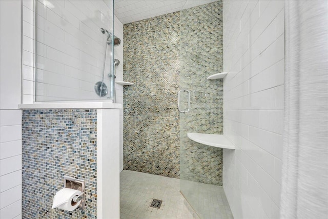 bathroom with a stall shower and tile walls