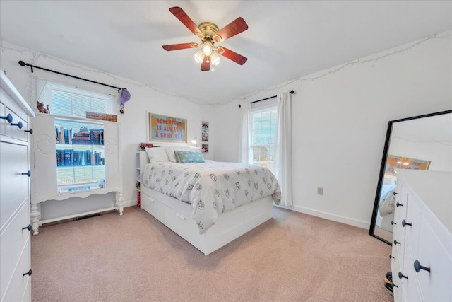 bedroom with light carpet, baseboards, and a ceiling fan