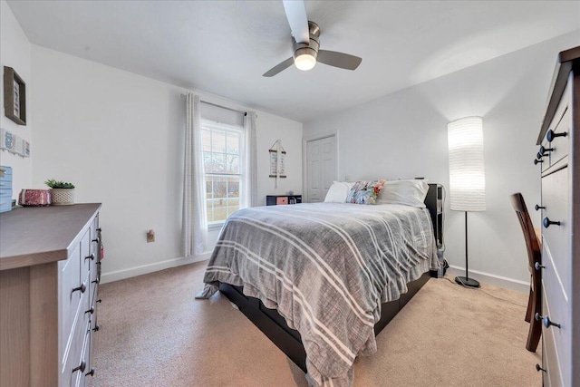 bedroom with ceiling fan, light colored carpet, and baseboards