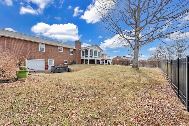 view of yard featuring a garage, fence private yard, and a sunroom