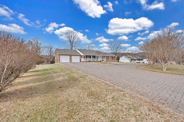 single story home featuring a garage, driveway, and a front lawn