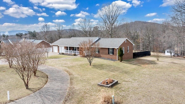 ranch-style house with a porch, a garage, brick siding, driveway, and a front yard