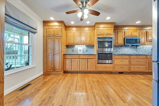 kitchen featuring stainless steel appliances, tasteful backsplash, dark countertops, and visible vents