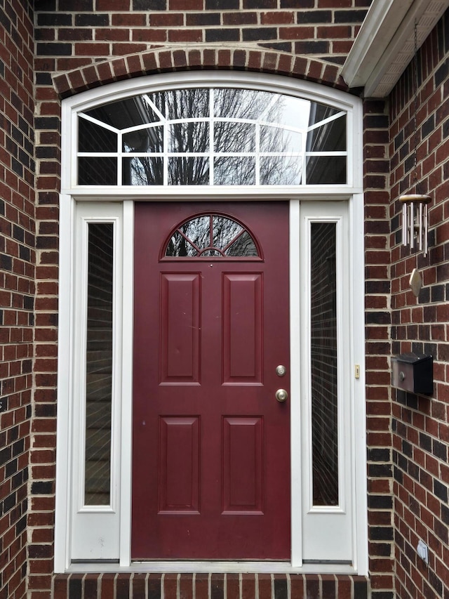 entrance to property featuring brick siding