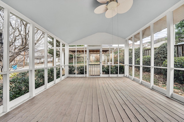 unfurnished sunroom featuring lofted ceiling, a wealth of natural light, and a ceiling fan