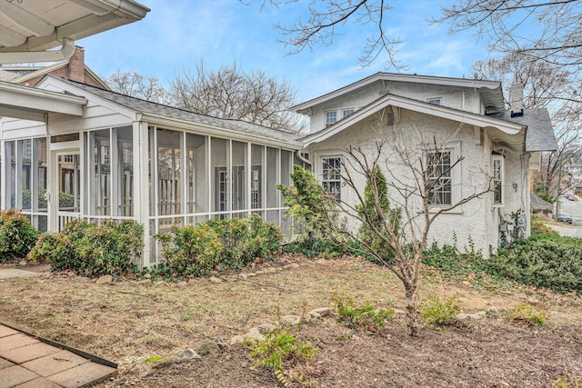 view of home's exterior featuring a sunroom and stucco siding