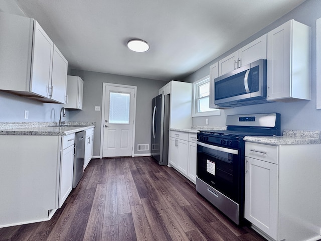 418 Victor Ave NE, Roanoke, VA 24012 - kitchen featuring appliances with stainless steel finishes, a sink, dark wood finished floors, white cabinetry, and visible vents