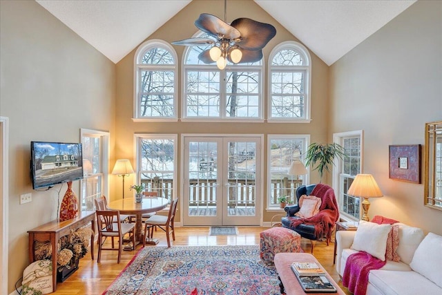 living area featuring ceiling fan, french doors, wood finished floors, and vaulted ceiling