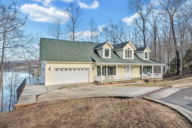 cape cod home with roof with shingles, a porch, concrete driveway, and an attached garage