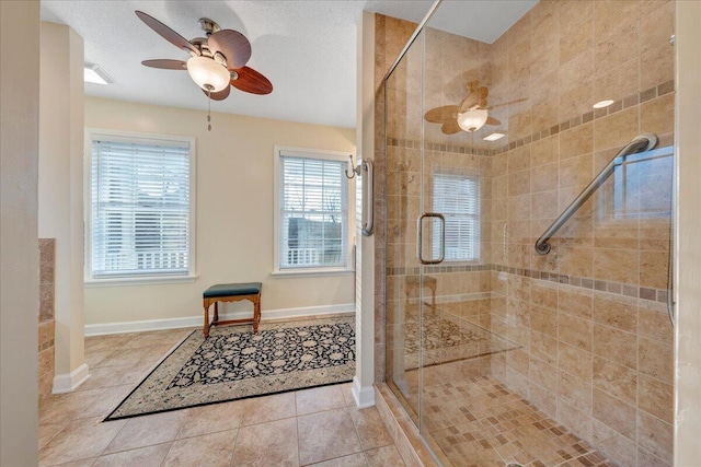 full bath with ceiling fan, baseboards, a stall shower, and tile patterned flooring