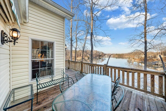 wooden terrace with outdoor dining area and a water view