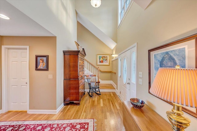 entryway with stairway, baseboards, and light wood-style floors