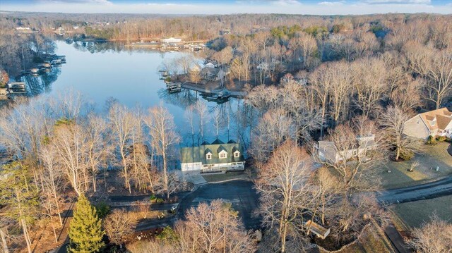 drone / aerial view with a wooded view and a water view