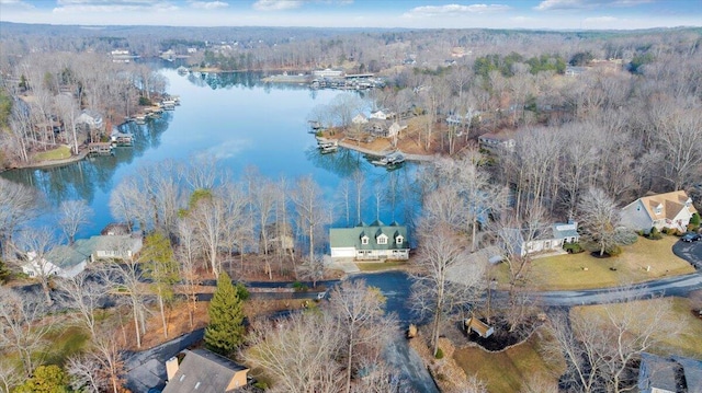 birds eye view of property featuring a forest view and a water view