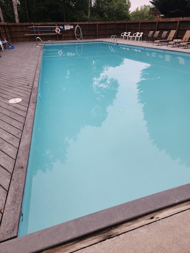 view of swimming pool featuring fence