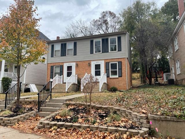 view of front of house featuring a chimney and brick siding