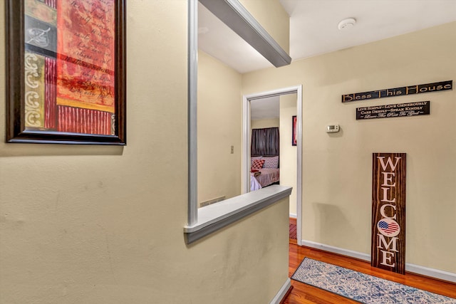 hallway featuring wood finished floors and baseboards