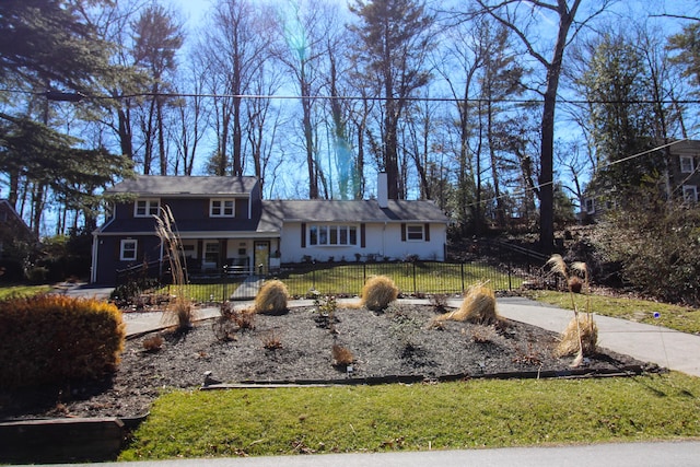 view of front of property featuring a fenced front yard and a chimney