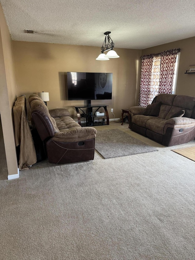 carpeted living room featuring a textured ceiling, visible vents, and baseboards