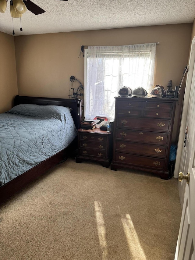 bedroom with light carpet, a textured ceiling, and a ceiling fan