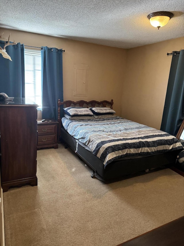 bedroom featuring light carpet and a textured ceiling