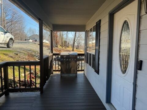 wooden deck with covered porch and area for grilling