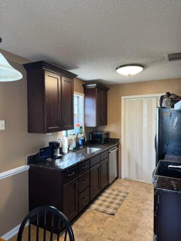 kitchen featuring black electric range, dark countertops, stainless steel dishwasher, and freestanding refrigerator